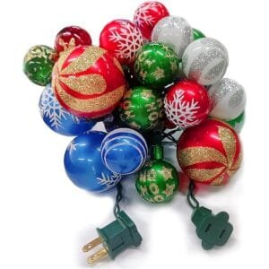 Colorful Christmas ornaments with festive designs, including red, green, blue, and silver, arranged with a green power cord for holiday decorating.