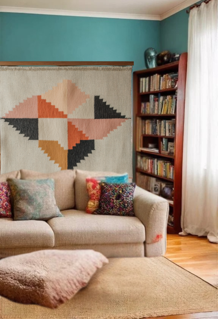 Cozy living room featuring a stylish couch, colorful pillows, and a geometric wall hanging, with a bookshelf and natural light enhancing the space.