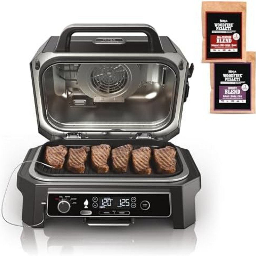 Ninja woodfire grill with steaks cooking, featuring digital controls and wood pellets for enhanced flavor. Ideal for grilling enthusiasts and outdoor cooking.