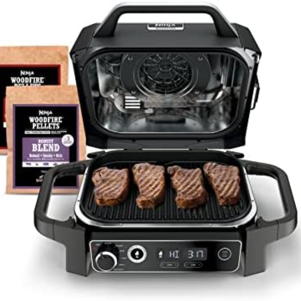 Ninja woodfire grill with steak cooking on the grill and woodfire pellets, showcasing versatile indoor grilling capabilities for flavorful meals.