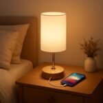 Modern bedside lamp with a warm glow, charging smartphone on a wooden nightstand, enhancing cozy bedroom ambiance. Perfect for reading or relaxation.