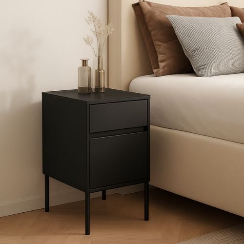 Modern black nightstand with two drawers, styled with decorative vases, complements a cozy bedroom setting with a beige bed and textured pillows.