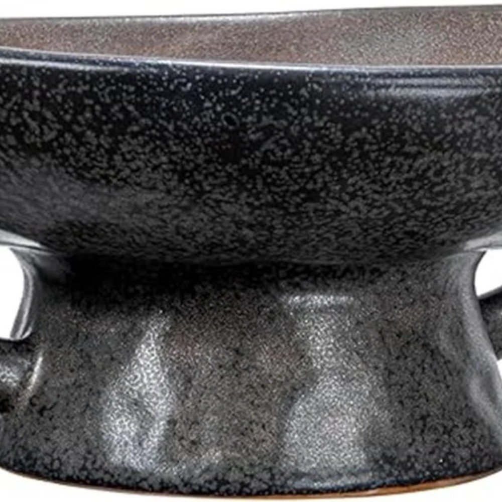 Black ceramic bowl with a textured finish, featuring a unique shape and design, ideal for serving or decorative purposes in modern kitchens.