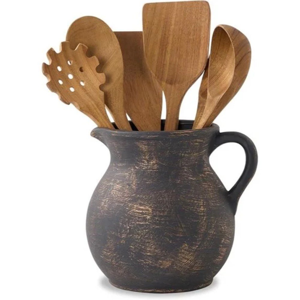 Wooden kitchen utensils in a rustic ceramic pitcher, perfect for cooking and serving. Stylish and functional addition to any kitchen decor.