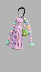 Colorful keychain featuring a purple tassel, pastel heart beads, and a cute green frog charm, perfect for adding charm to bags or keys.